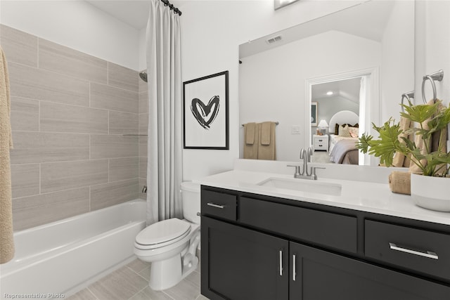 ensuite bathroom with shower / tub combo with curtain, toilet, connected bathroom, vanity, and tile patterned flooring