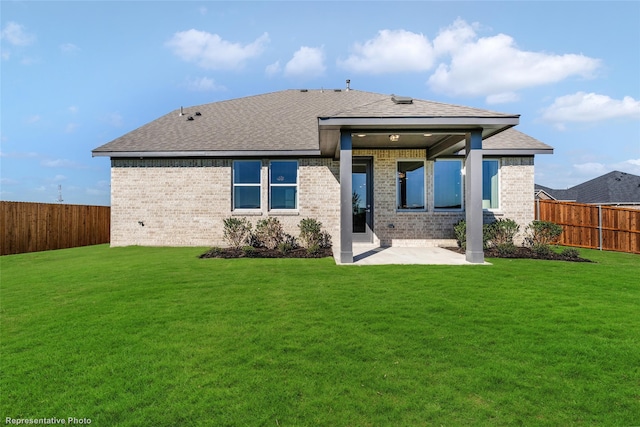 rear view of property with a patio, a lawn, and a fenced backyard