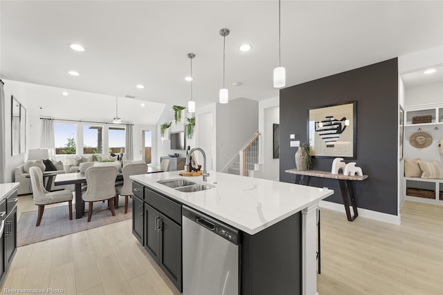 kitchen featuring light wood-style floors, open floor plan, a kitchen island with sink, a sink, and dishwasher