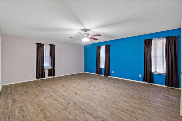 unfurnished room featuring ceiling fan, wood finished floors, and baseboards