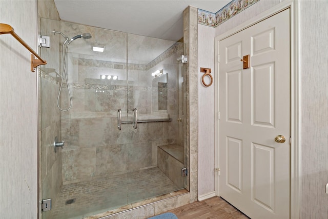 bathroom with a stall shower and wood finished floors