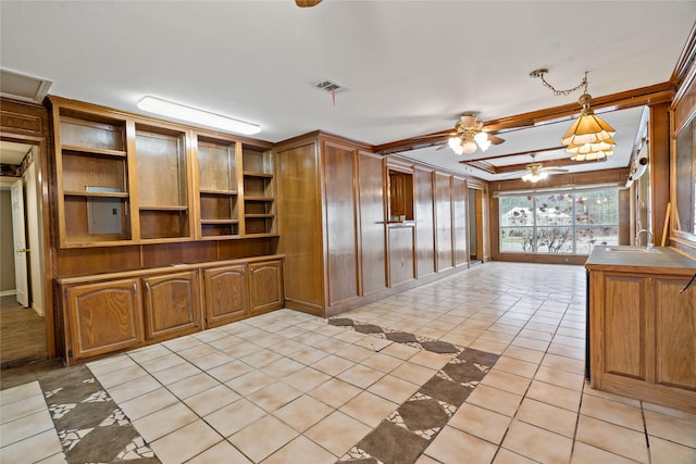 kitchen featuring crown molding, brown cabinets, a ceiling fan, and light tile patterned flooring