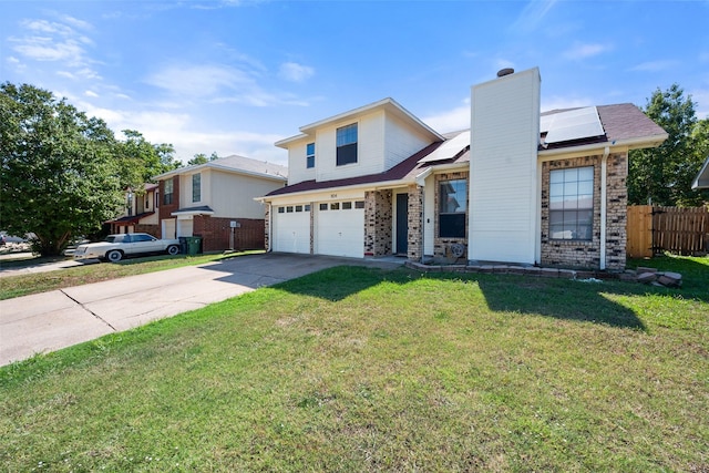 traditional home with solar panels, concrete driveway, a front yard, fence, and a garage