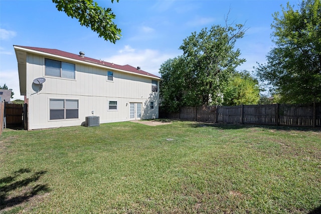 view of yard featuring central AC, french doors, and a fenced backyard