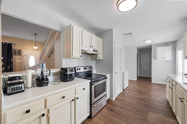 kitchen featuring visible vents, dark wood finished floors, light countertops, stainless steel range with electric cooktop, and under cabinet range hood