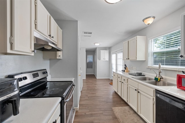 kitchen featuring black dishwasher, stainless steel electric range oven, wood finished floors, under cabinet range hood, and a sink