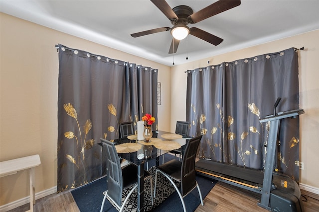 dining room with a ceiling fan, baseboards, and wood finished floors