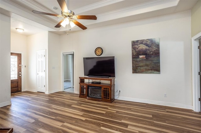 living area featuring baseboards, wood finished floors, and crown molding