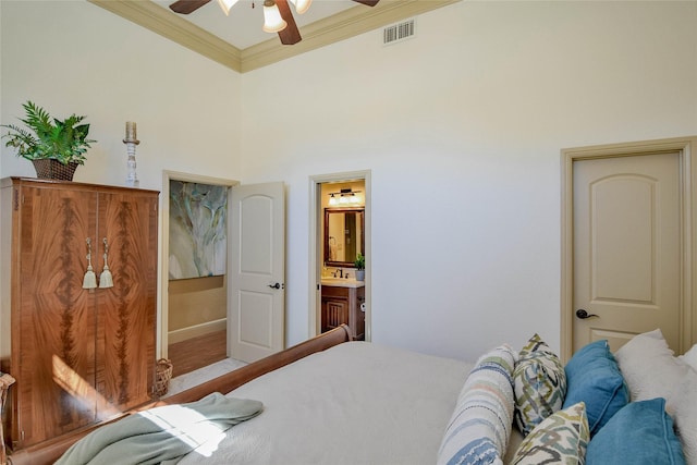 bedroom with crown molding, visible vents, a ceiling fan, connected bathroom, and a sink