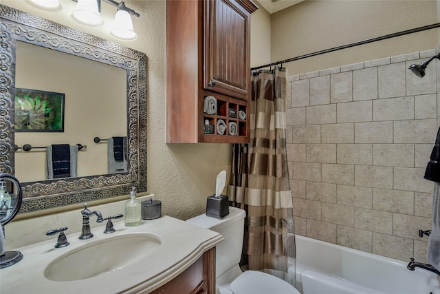 full bath featuring toilet, a textured wall, vanity, and shower / tub combo with curtain