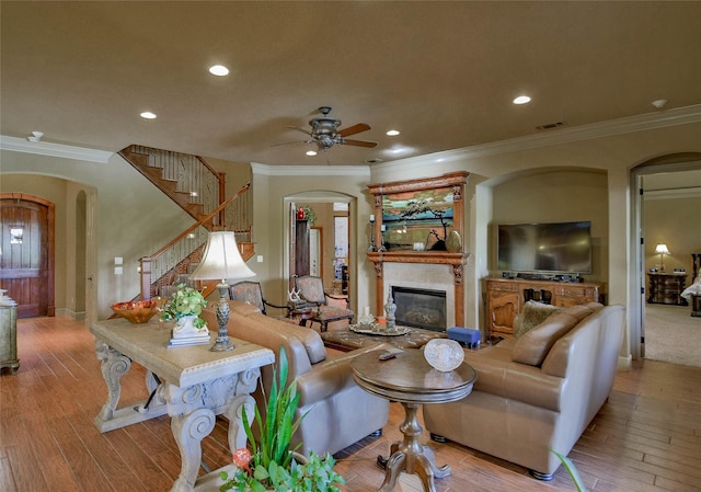 living area with arched walkways, visible vents, and a glass covered fireplace