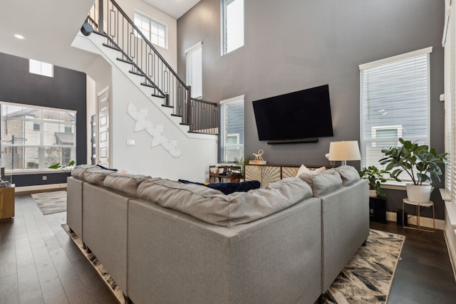 living room with dark wood-style flooring, a healthy amount of sunlight, and baseboards