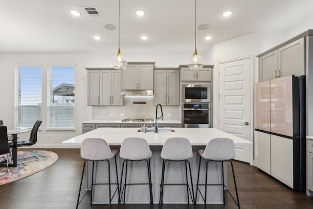 kitchen featuring a sink, appliances with stainless steel finishes, gray cabinets, and visible vents