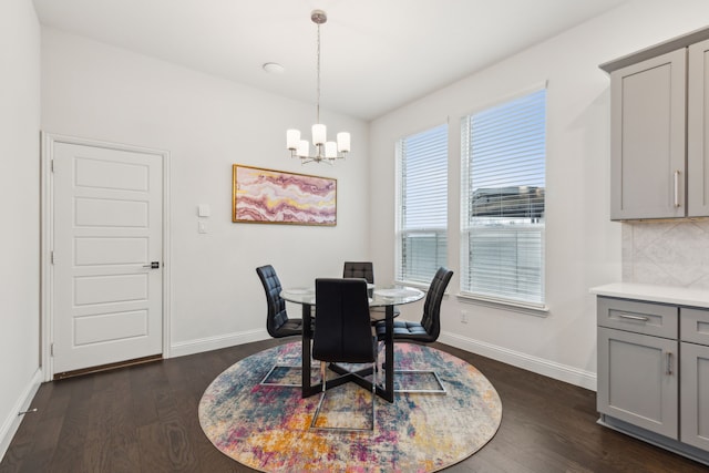 dining space featuring dark wood-style floors, baseboards, and a chandelier