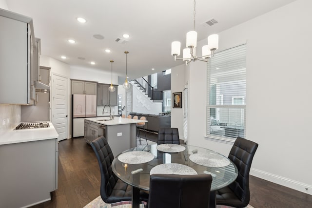 dining room with stairway, dark wood finished floors, visible vents, and a notable chandelier