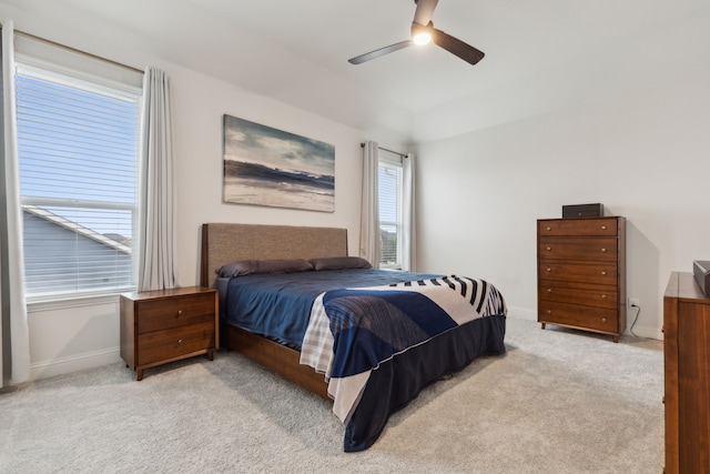 bedroom featuring a ceiling fan, light carpet, and baseboards