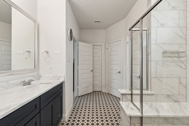 full bath with a stall shower, visible vents, baseboards, tile patterned floors, and vanity