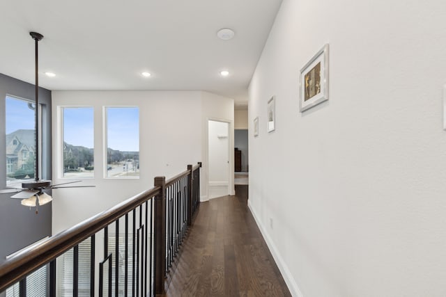 hallway with recessed lighting, dark wood finished floors, an upstairs landing, and baseboards