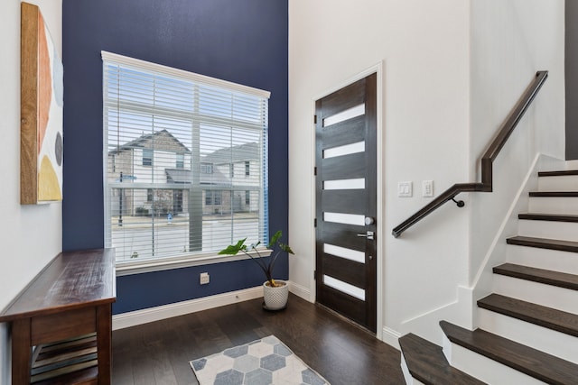 entrance foyer featuring baseboards, stairway, and dark wood-type flooring