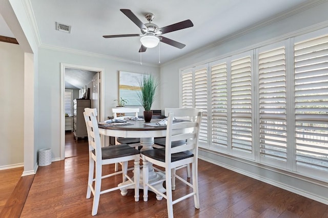 dining area with visible vents, ornamental molding, ceiling fan, wood finished floors, and baseboards