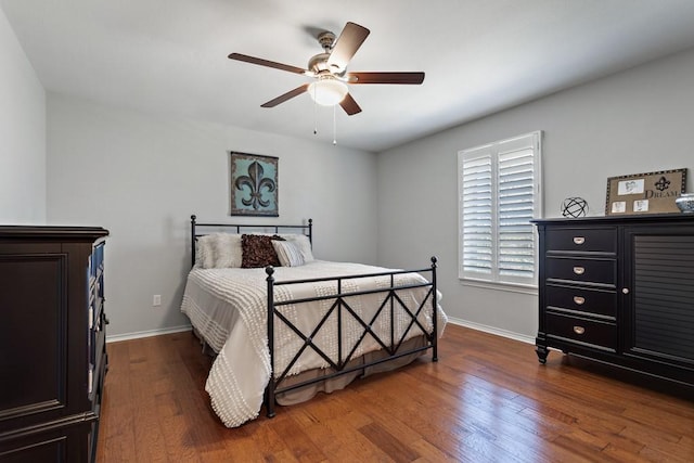 bedroom featuring baseboards, dark wood finished floors, and a ceiling fan