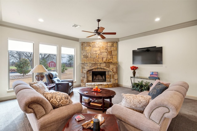 living room featuring a stone fireplace, visible vents, baseboards, carpet, and crown molding