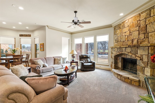 living room with carpet floors, recessed lighting, crown molding, and a stone fireplace