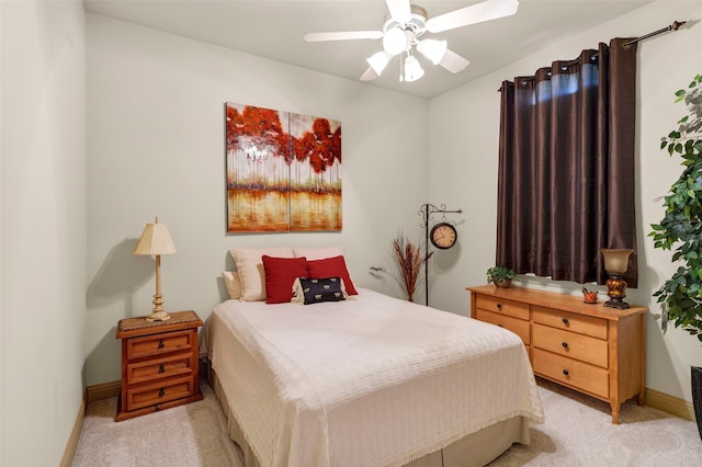 bedroom with light carpet, a ceiling fan, and baseboards