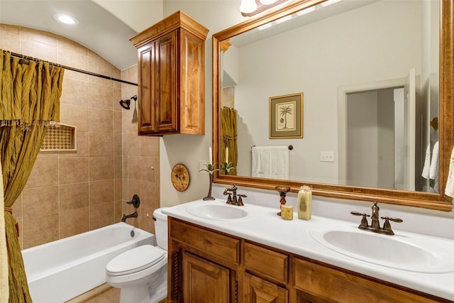 bathroom with double vanity, shower / tub combo, a sink, and toilet