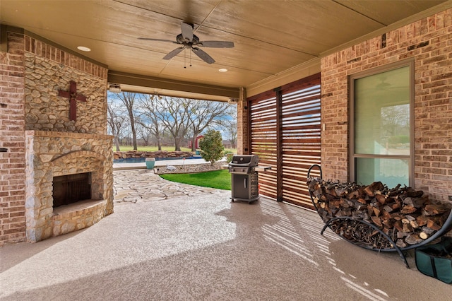 view of patio / terrace featuring a ceiling fan, an outdoor stone fireplace, and grilling area