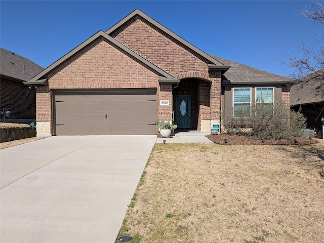 view of front of house featuring a garage, brick siding, driveway, and a shingled roof