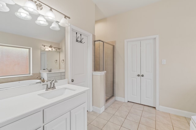 bathroom with baseboards, tile patterned floors, vanity, a shower stall, and a closet