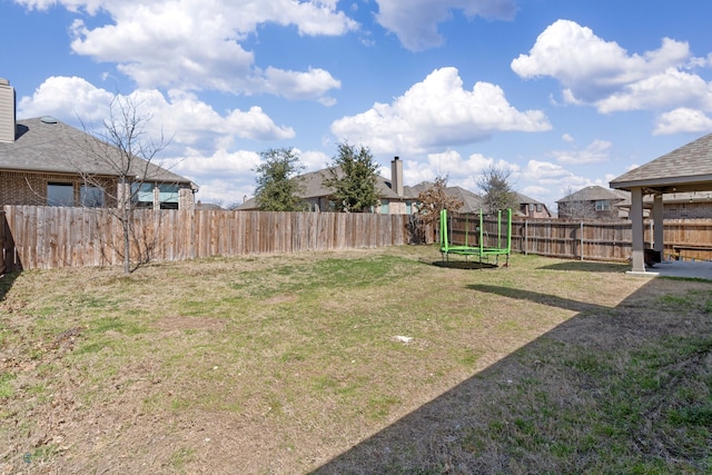 view of yard featuring a fenced backyard and a trampoline