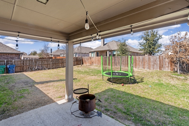 view of yard featuring a patio area, a fenced backyard, and a trampoline