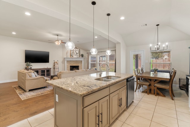 kitchen with visible vents, dishwasher, vaulted ceiling, a fireplace, and a sink