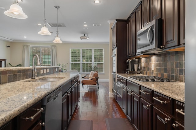 kitchen featuring stainless steel appliances, a sink, visible vents, and crown molding