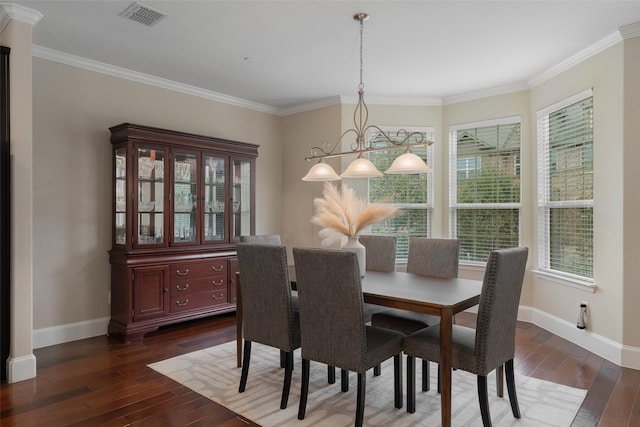 dining room featuring dark wood-style floors, ornamental molding, visible vents, and baseboards