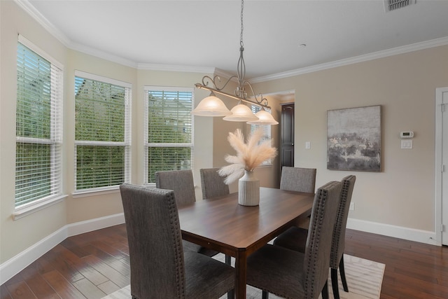 dining space featuring baseboards, wood finished floors, visible vents, and crown molding