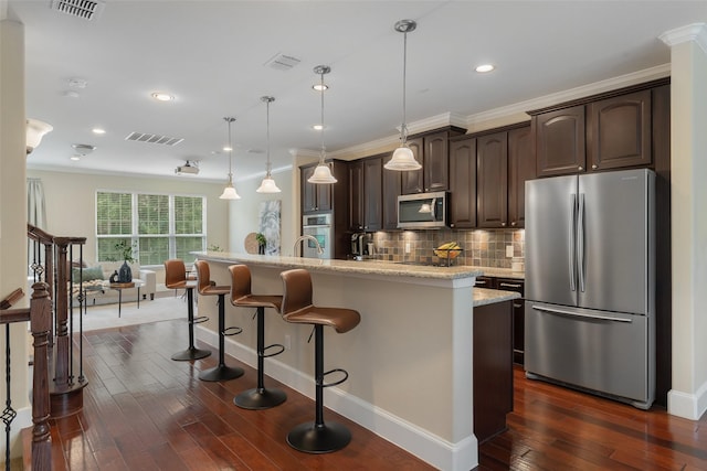 kitchen featuring visible vents, dark brown cabinets, appliances with stainless steel finishes, decorative backsplash, and crown molding