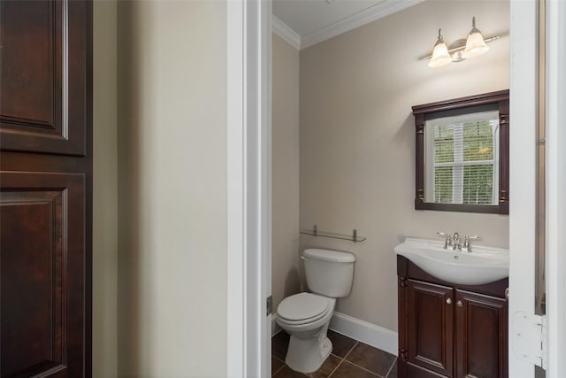 half bath with crown molding, toilet, vanity, baseboards, and tile patterned floors