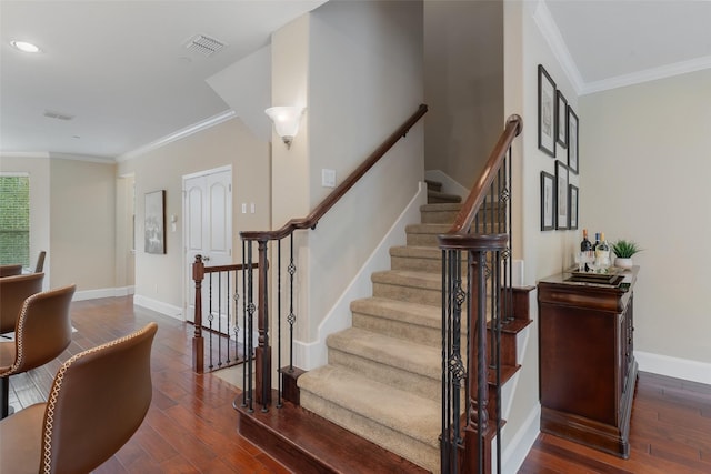 stairway with visible vents, crown molding, baseboards, and hardwood / wood-style flooring