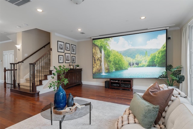 living room featuring wood finished floors, visible vents, baseboards, ornamental molding, and stairway