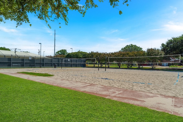 view of home's community with volleyball court, a lawn, and fence