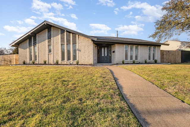 mid-century inspired home with fence, a front lawn, and brick siding