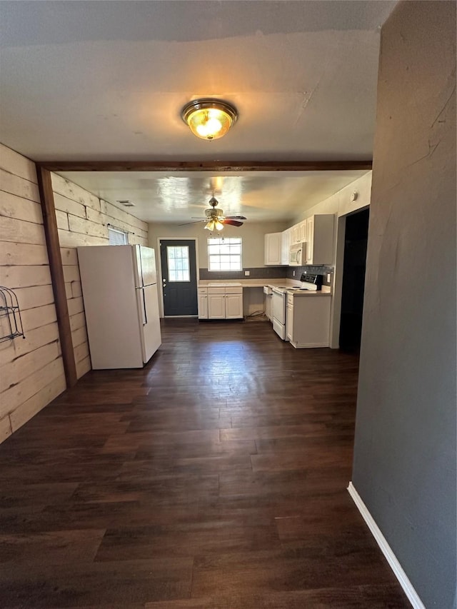 kitchen featuring wooden walls, white appliances, dark wood-style flooring, white cabinets, and light countertops