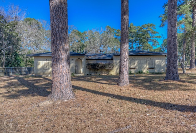 rear view of property featuring fence and brick siding