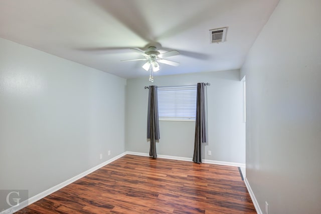 spare room with ceiling fan, wood finished floors, visible vents, and baseboards