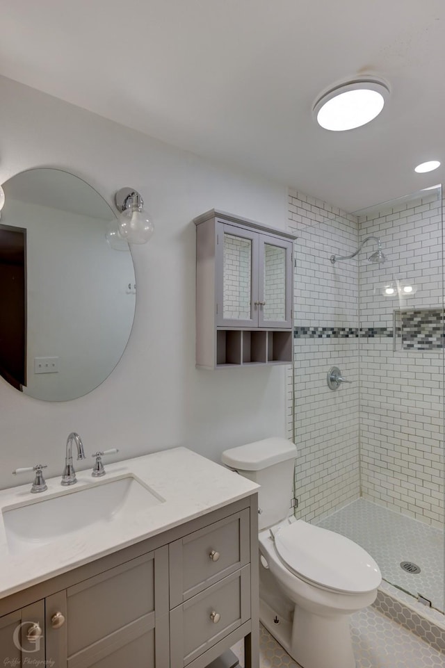 bathroom featuring a shower stall, toilet, and vanity