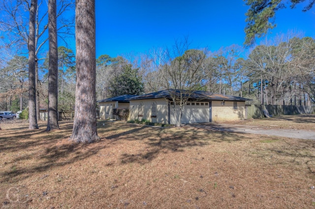 view of front of house featuring brick siding, a front yard, fence, a garage, and driveway