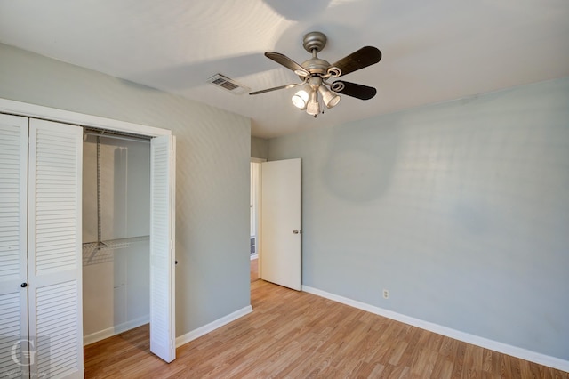 unfurnished bedroom featuring a ceiling fan, baseboards, visible vents, light wood-style floors, and a closet